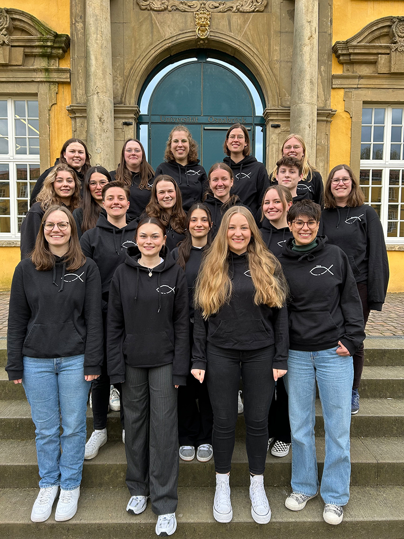 Die Studierenden der Fachschaft stehen auf der Schlosstreppe und lächeln in die Kamera